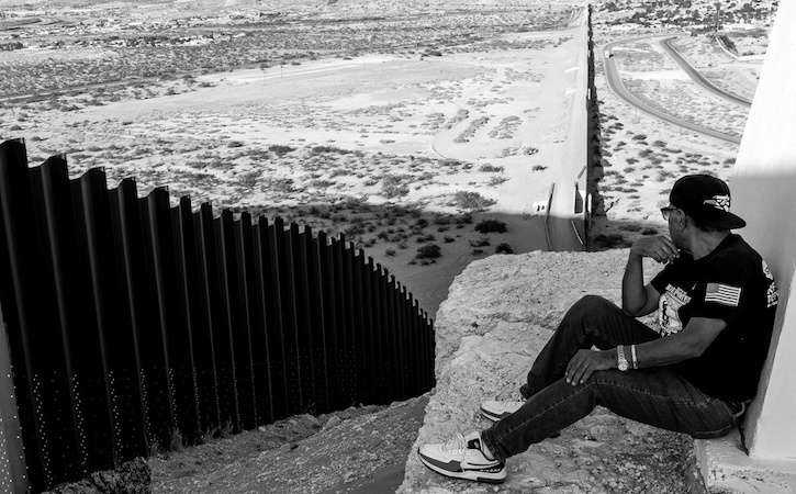 Jose Francisco Lopez Moreno overlooking fence at U.S.-Mexico border