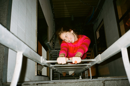 Camille Cohen on a ladder posing for the camera 