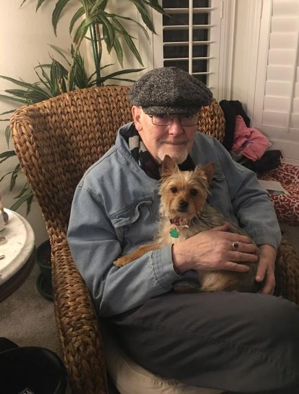 John Burks sitting holding his dog 